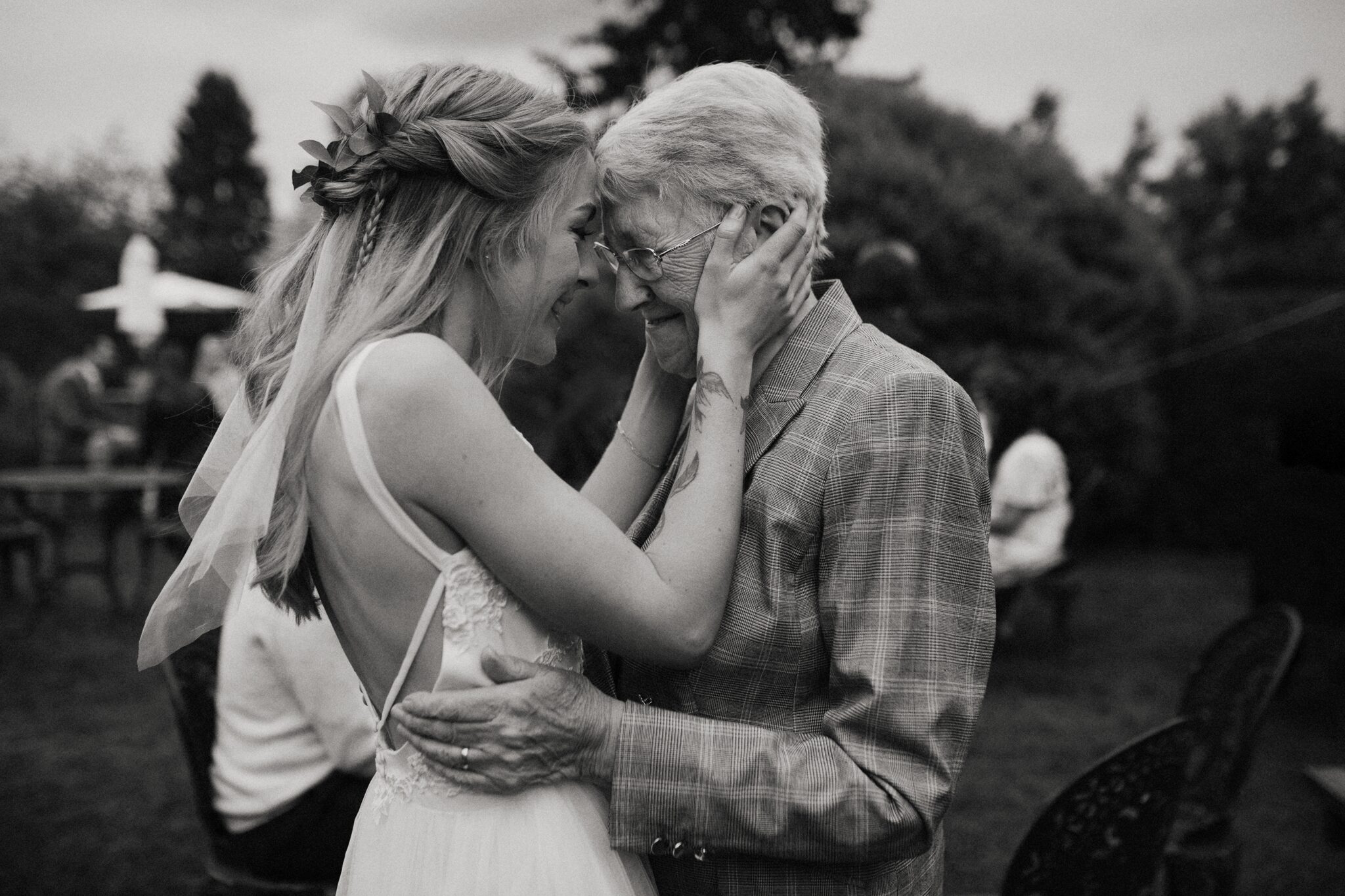 Candid timeless photo of a bride and her grandma hugging head to head on her wedding day