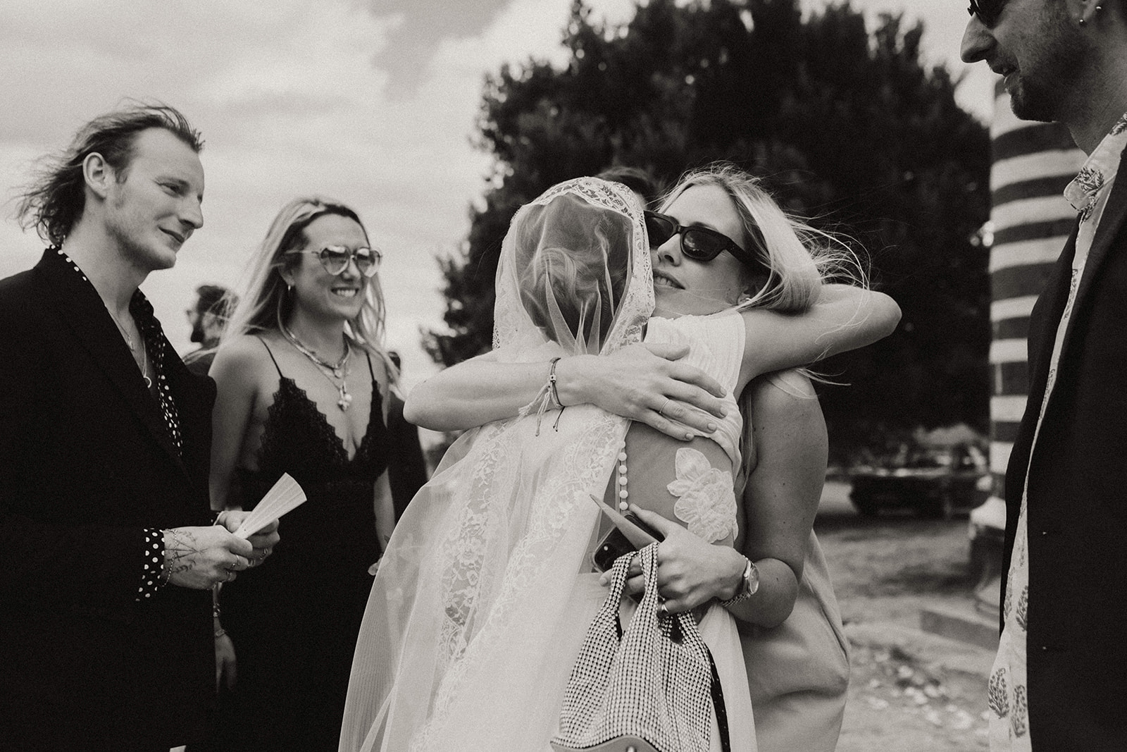Black and white timeless photograph of a bride hugging a friend on her wedding day in Corsica